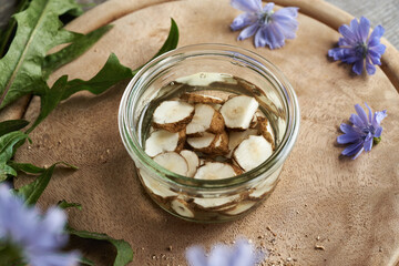 Making chicory root tincture in a glass jar on a table