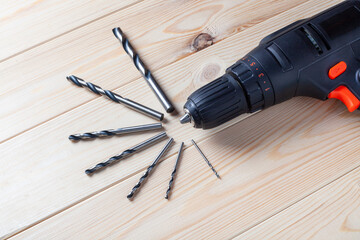 Close up Electric drill, Drill set, Screwdriver set on wooden table background. Electric cordless hand drill on wooden. maintenance home concept
