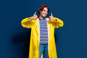 Photo of optimistic young attractive woman tourist showing thumbs up likes new the north face collection isolated on blue color background