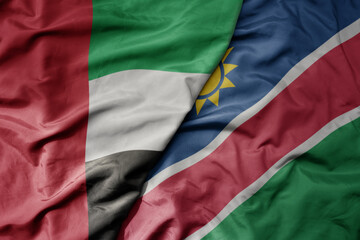 big waving realistic national colorful flag of united arab emirates and national flag of namibia .