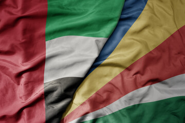 big waving realistic national colorful flag of united arab emirates and national flag of seychelles .