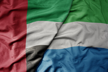 big waving realistic national colorful flag of united arab emirates and national flag of sierra leone .