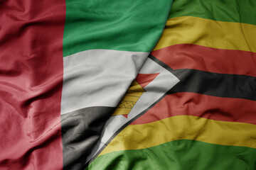 big waving realistic national colorful flag of united arab emirates and national flag of zimbabwe .