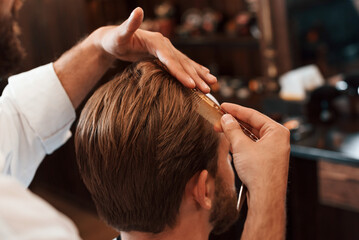 Getting haircut. Man is visiting modern barber shop. Modern style