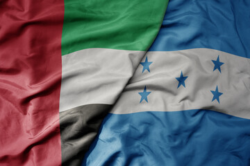 big waving realistic national colorful flag of united arab emirates and national flag of honduras .