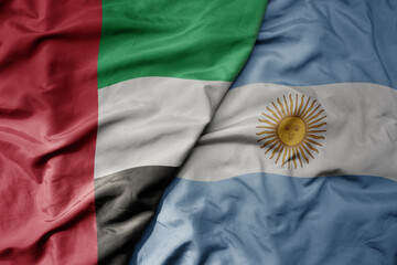 big waving realistic national colorful flag of united arab emirates and national flag of argentina .