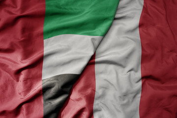big waving realistic national colorful flag of united arab emirates and national flag of peru .