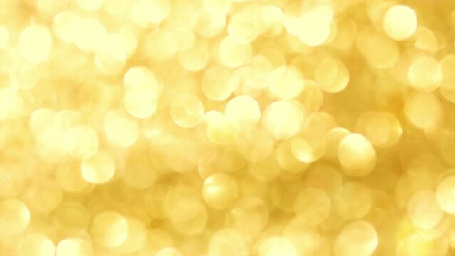 Festive glitter blurred shining gold 
background with bokeh and highlights.