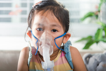 Kid girl making makes inhalation nebulizer steam sick cough at home, Asian Child using nebulizer...