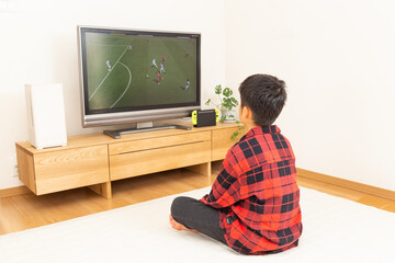 テレビでサッカー観戦をする子供