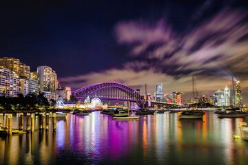 Beautiful view of river with boats and bridge with modern architectures of Sydney at night