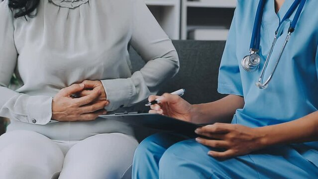 Doctor And Patient Sitting And Talking At Medical Examination At Hospital Office, Close-up. Therapist Filling Up Medication History Records. Medicine And Healthcare Concept.