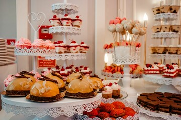 Diverse selection of cakes and other sweet treats arranged on a table at a wedding reception