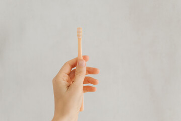 toothbrush in the hand of a girl on a white background