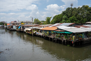 Fototapeta na wymiar A klong or river channel of Chao Phraya river with residential buildings in Bangkok Thailand Asia