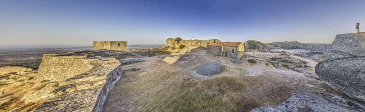 Panoramic image of the fortification above the historic town of Monsanto in Portugal during sunrise