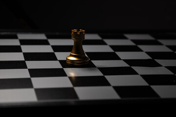 Gold Rook Chess Placed on a chess board in a dark room. For creating business-related content 