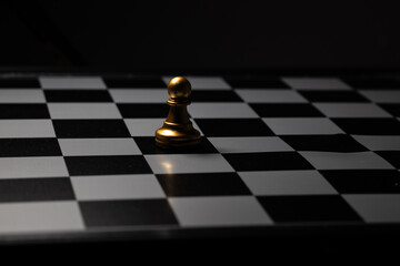 Gold Pawn Chess Placed on a chess board in a dark room. For creating business-related content 