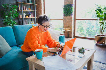 Photo of good mood cheerful mature lady dressed orange sweater typing apple samsung modern device...