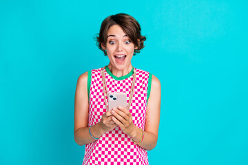 Photo of crazy funny young woman surprised looking smartphone new interface after update advert ios isolated on aquamarine color background