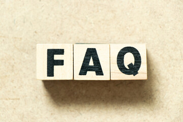 Alphabet letter block in word FAQ (Abbreviation of Frequently asked questions) on wood background