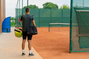 young professional player coach standing on outdoor tennis court before starting game training with...
