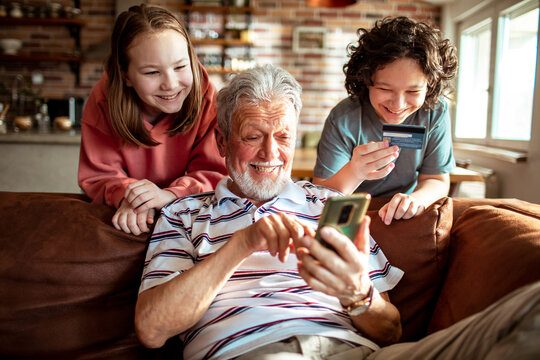 Grandfather online shopping with his grandchildren on the smartphone at home