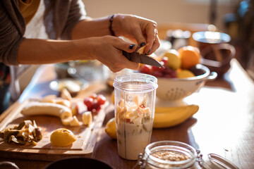 Young Caucasian woman preparing a healthy and organic shake in the kitchen at home