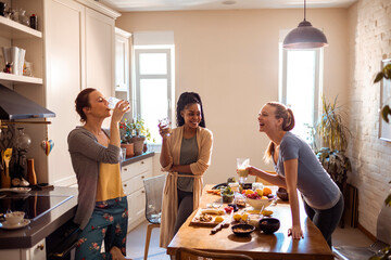 Young and diverse group of friends having organic made shakes in the kitchen at home