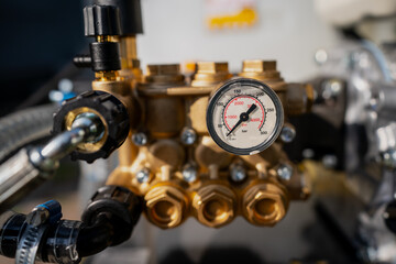 Water pressure gauge close up with valves and engine