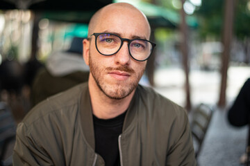 Obraz premium portrait handsome man with the glasses at the terrace of a restaurant in the evening