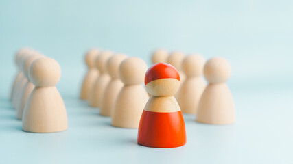 A red wooden figure standing with a team to influence and empowerment. Concept of leadership,...