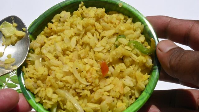 Vegetable Poha in India. It is made by mixing vegetables, poha and spices. Rice is parboiled before flattening so that it can be consumed with very little to no cooking. Indian breakfast.
