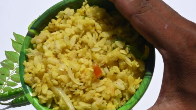 Vegetable Poha in India. It is made by mixing vegetables, poha and spices. Rice is parboiled before flattening so that it can be consumed with very little to no cooking. Indian breakfast.