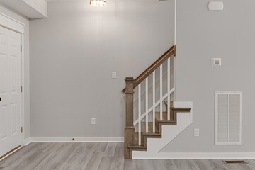 Foyer Entryway with Staircase and Wood Railing. Warm Natural Floors and Minimal