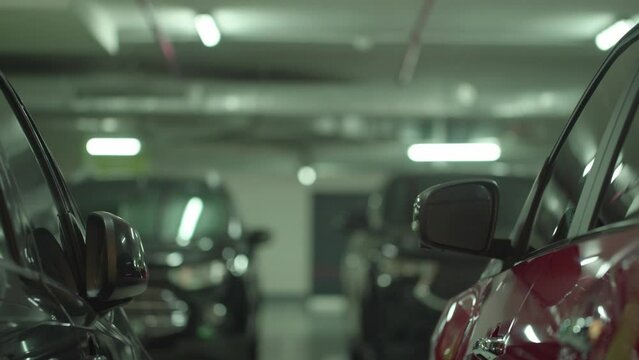 Modern underground parking with unrecognizable moving cars, focusing on the foreground 4K
