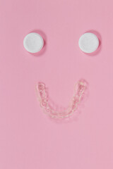 Effervescent cleaning tablets with teeth retainer on a pastel pink background