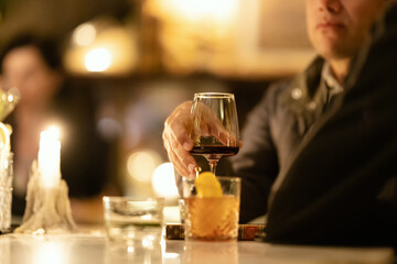 A man drinks red wine at the bar