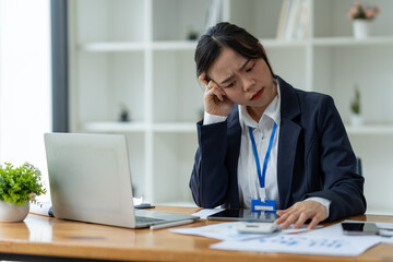 Young Asian businesswoman tired from working long hours, stressed, tired of thinking. Ideas for planning, presenting financial reports, investments, business plans, modern concepts online.