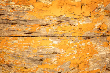 Old yellow wooden surface with shabby background paint. Yellow cracked paint texture on a wooden...