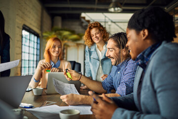 Young and diverse group of designers having a meeting in an office while working in a startup company