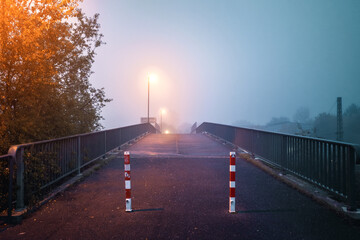 Laternen auf Brücke bei Nebel und intensiver Beleuchtung
