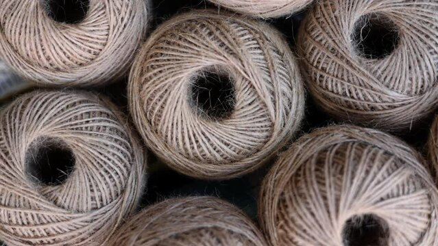 rolls of natural hemp wire for parcel twine, string, packing or diy.fencing strand,polypropylene orange, blue twine.spools in plastic bag,woman hand,market store sale concept.thick rope texture