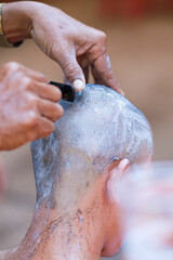 Fototapeta premium The culture of shaving men's hair is preparation before the Buddhist monk ordination ceremony.