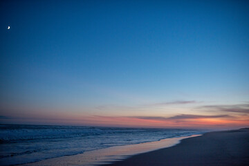 Amagansett, NY after sunset red glow with moon in the foreground