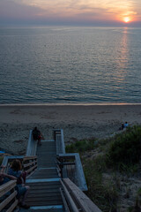 People capture and enjoy Cape cod summet sunset on steep stairs
