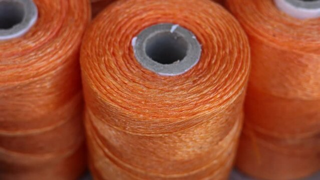 rolls of natural hemp wire for parcel twine, string, packing or diy.fencing strand,polypropylene orange, blue twine.spools in plastic bag,woman hand,market store sale concept.thick rope texture