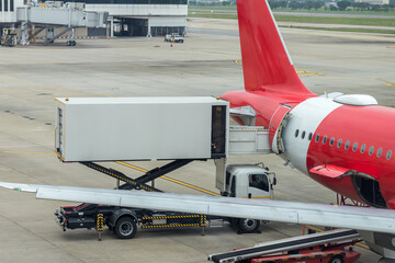 Loading cargo on the plane in airport. Process of cargo handling. Parcels loading with high loader...