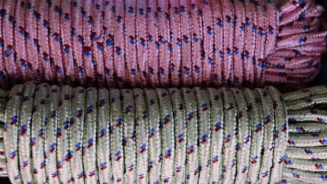 rolls of natural hemp wire for parcel twine, string, packing or diy.fencing strand,polypropylene orange, blue twine.spools in plastic bag,woman hand,market store sale concept.thick rope texture