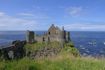 Fototapeta na wymiar Dunluce Castle on Irish Sea and Atlantic Ocean Co Antrim Northern Ireland with blue sea background